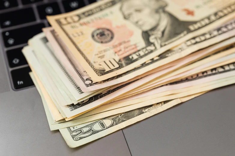 a pile of money sitting on top of a laptop, a portrait, by Josh Bayer, pixabay, instagram post, profile image, closeup, cash on a sidetable