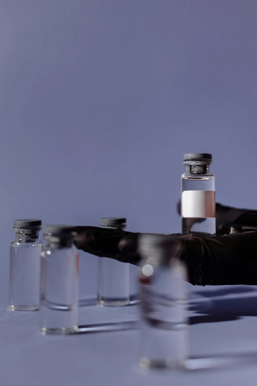 a group of vials sitting on top of a table, an album cover, ektachrome color photograph, sleek hands, medical research facility, thumbnail