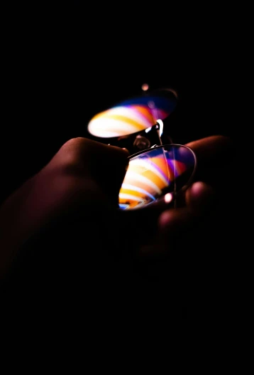 a person holding a lighter in their hand, a microscopic photo, by Adam Chmielowski, holography, reflective aviator sunglasses, ((sharp focus)), color light waves, multi colored
