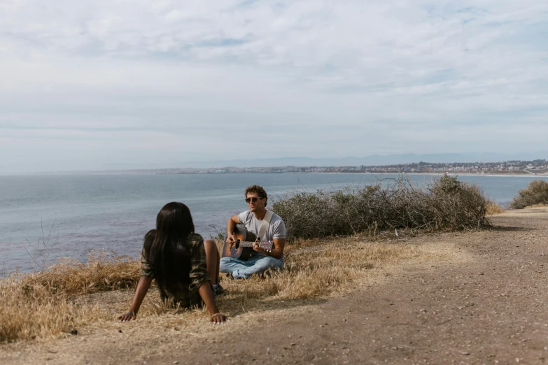 a man and a woman sitting on a hill next to the ocean, pexels contest winner, singer songwriter, pokimane, picnic, sydney park