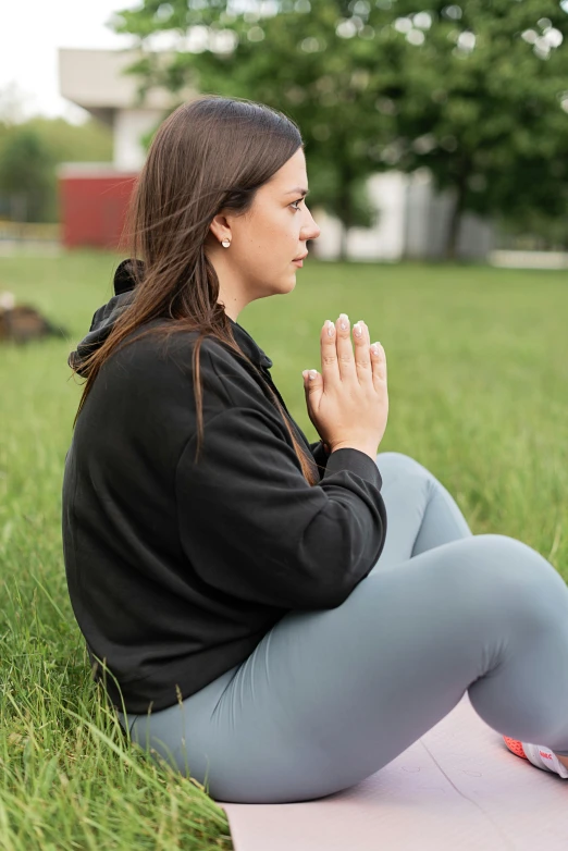 a woman sitting on top of a pink yoga mat, renaissance, sitting on one knee on the grass, wearing a grey hooded sweatshirt, praying posture, profile image