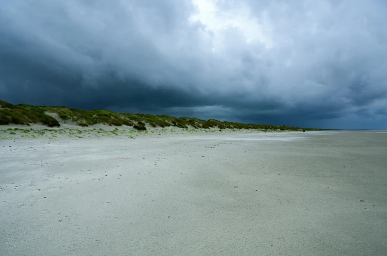 a white sandy beach under a cloudy sky, by Andries Stock, unsplash, ravens stormy sky of foreboding, mayo, taken in the late 2000s, modeled