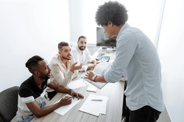 a group of men sitting around a wooden table, pexels contest winner, teaching, on a white table, awarding winning, sitting in office