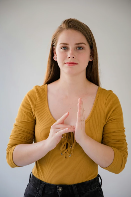 a woman making a gesture with her hands, a picture, by Matthias Stom, unsplash, portrait of white teenage girl, sukhasana, promo image, 3/4 front view