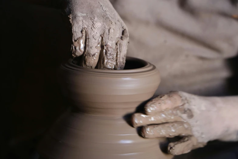 a close up of a person making a pot on a potter's wheel, inspired by Hendrik Gerritsz Pot, pexels contest winner, process art, giant clay statue, thumbnail, brown, elegant intricate