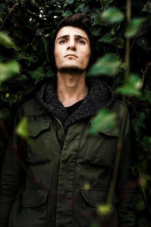 a man standing in the middle of a forest, by Jesper Knudsen, ville valo, headshot profile picture, lush greens, joe keery