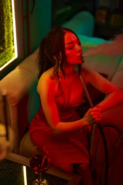 a woman in a red dress sitting on a couch, an album cover, inspired by Elsa Bleda, trending on pexels, a hookah smoking caterpillar, “megan fox, thick pigmented smoke, nightclub