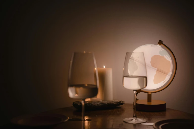 a globe sitting on top of a table next to a glass of wine, inspired by Georges de La Tour, trending on unsplash, magical realism, soft coloured gel lighting, bisexual lighting, 3 d render even lit, two moons lighting