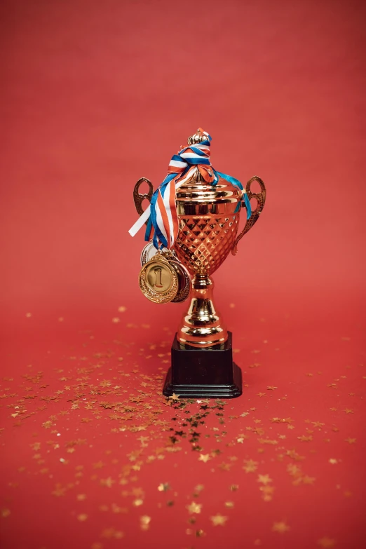 a golden trophy sitting on top of a red surface, pexels contest winner, red and blue color scheme, ribbons, portrait shot, spangled