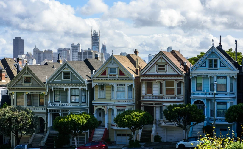 a row of houses with a city in the background, by Jessie Algie, pexels contest winner, art nouveau, stephen shore, a wooden, former