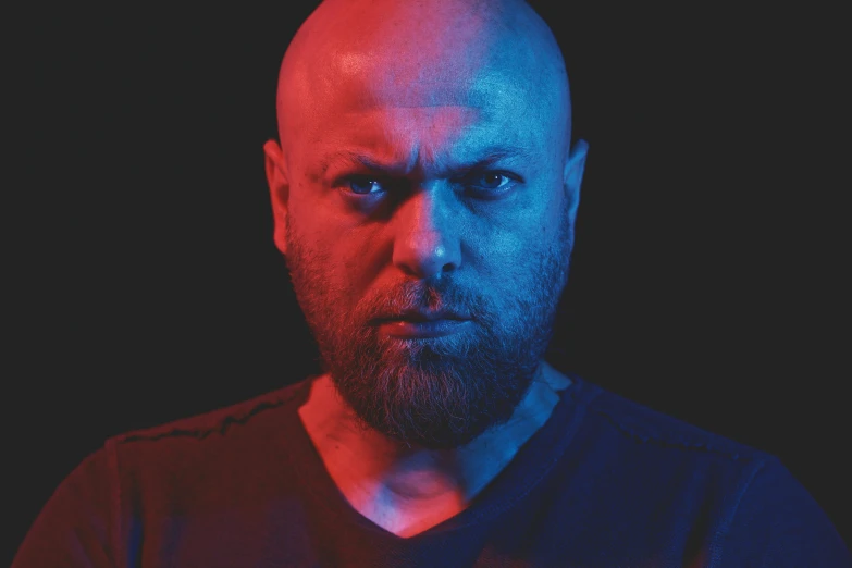 a bald man with a beard stares at the camera, an album cover, inspired by Volkan Baga, unsplash, red and blue black light, soft portrait shot 8 k, portrait of gigachad, photo from a promo shoot