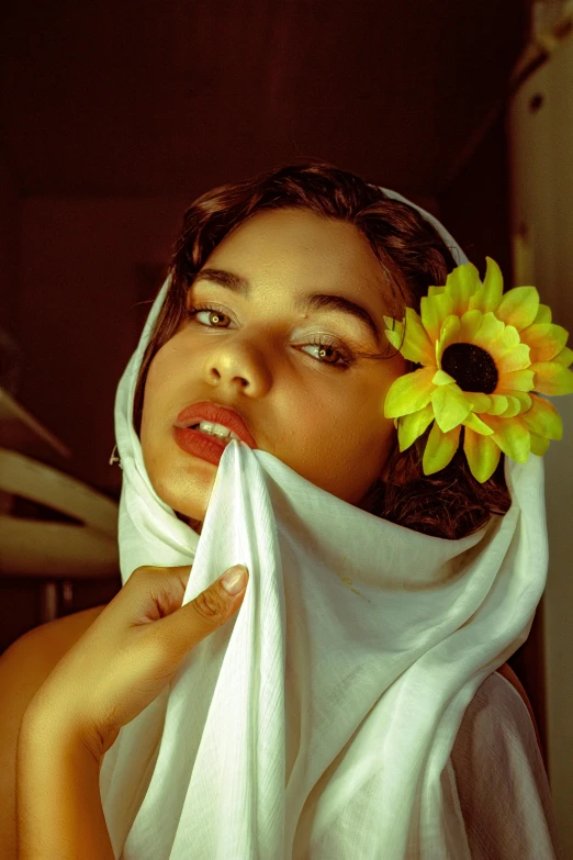 a woman with a sunflower in her hair, a colorized photo, inspired by Pierre Auguste Cot, unsplash, wearing a towel, imaan hammam, fully covered in drapes, seducing expression