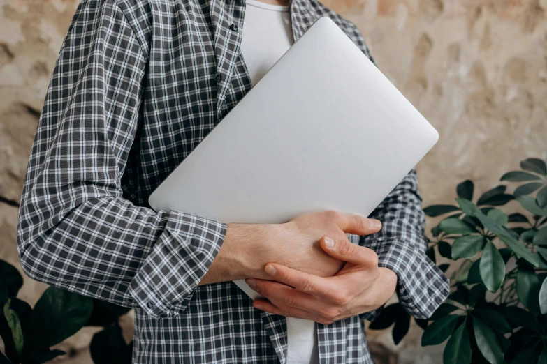 a man holding a laptop computer in his hands, by Carey Morris, trending on pexels, white sleeves, classic gem, background image, handcrafted