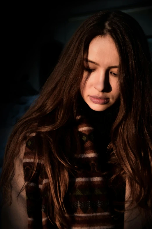 a close up of a person holding a cell phone, an album cover, inspired by Elsa Bleda, antipodeans, dark brown long hair, pensive expression, dark. no text, young woman looking up