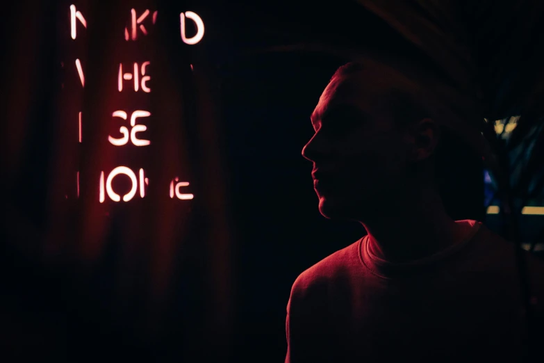 a man standing in front of a neon sign, inspired by Niko Henrichon, pexels contest winner, kind face, red skinned, 'he knows what you did ', ( ( theatrical ) )