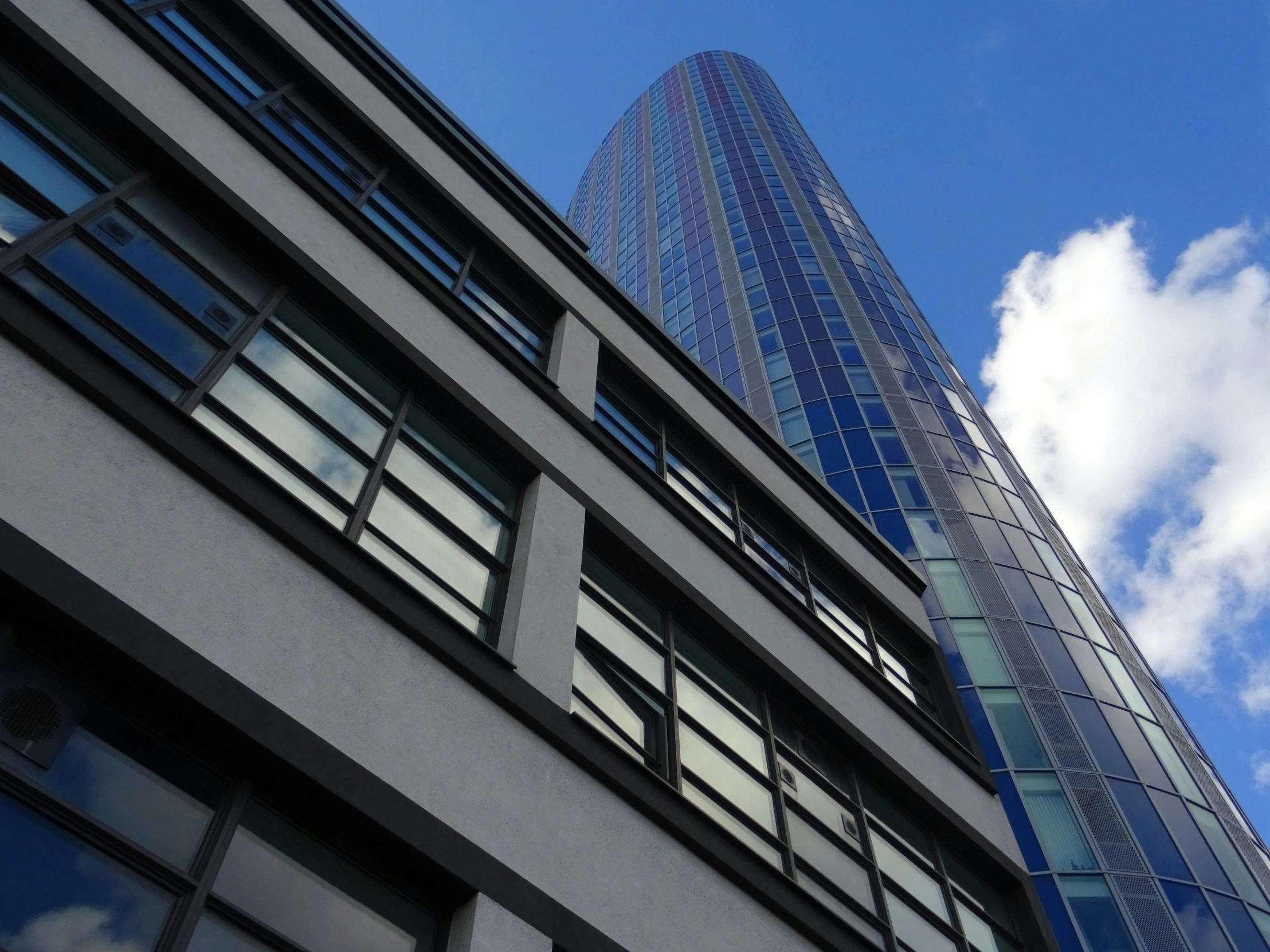 a tall building with a blue sky in the background, a photo, inspired by Richard Wilson, glazing, grey, slide show, tungsten