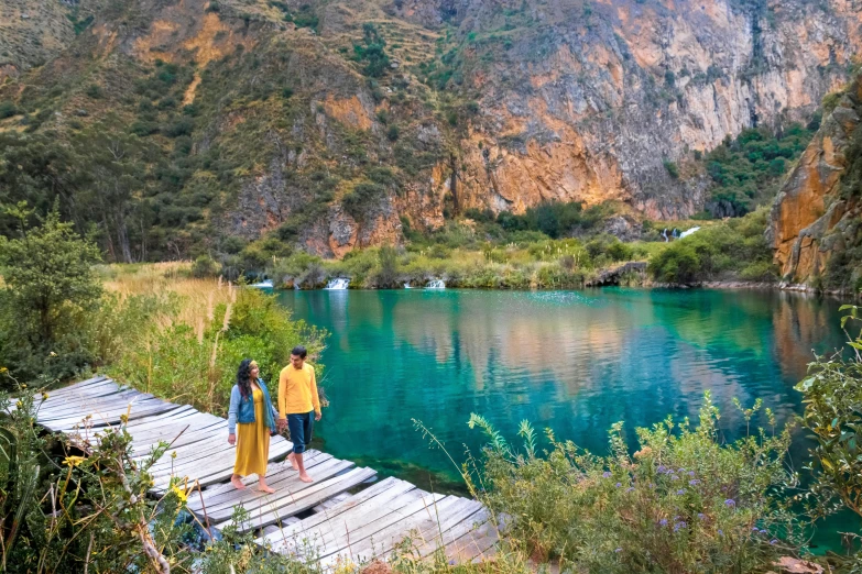 a couple of people that are standing on a dock, hurufiyya, quechua, turquoise water, avatar image, conde nast traveler photo