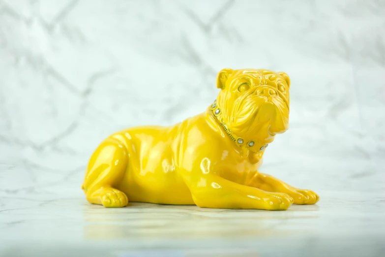 a close up of a figurine of a dog, an art deco sculpture, inspired by Fernando Botero, instagram, yellow, lying, made of crystal, boxer