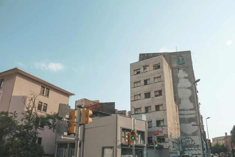 a street filled with lots of traffic next to tall buildings, an album cover, pexels contest winner, brutalism, old abandoned building, tel aviv street, sunfaded, seen from the side