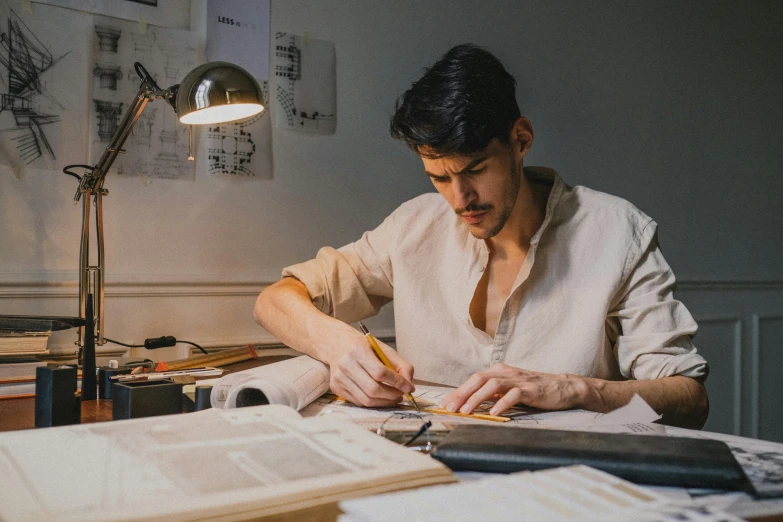 a man sitting at a desk writing on a piece of paper, a drawing, by Alexander Runciman, pexels contest winner, academic art, costume design made with love, eng kilian, sydney hanson, press shot