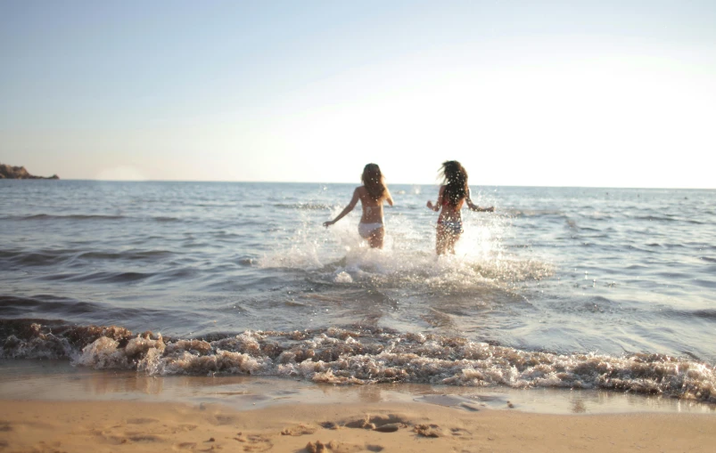 two girls are playing in the water at the beach, unsplash, figuration libre, running freely, beautiful italian beach scene, profile image, 8 k -