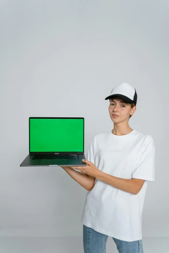 a woman holding a laptop with a green screen, a computer rendering, by Matthias Stom, wearing a baseball cap, on a gray background, product image, thin young male