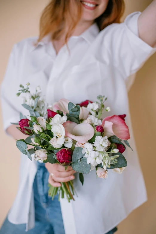 a woman in a white shirt holding a bouquet of flowers, inspired by François Boquet, unsplash, 3/4 front view, white and pink cloth, red and white flowers, smooth curves