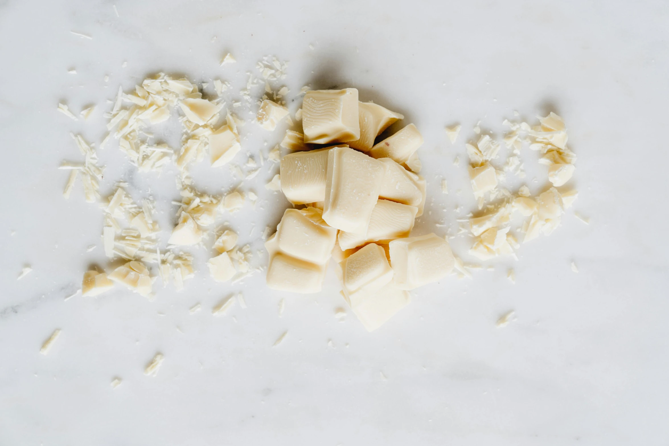 a pile of white cheese sitting on top of a counter, by Jessie Algie, unsplash, fully chocolate, square shapes, crushed, vanilla