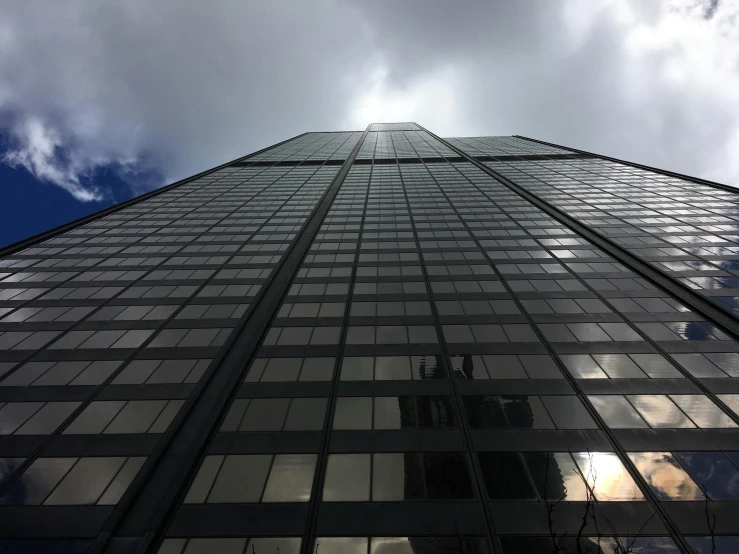 a very tall building with a lot of windows, an album cover, unsplash, chicago, gopro photo, under a gray foggy sky, exterior photo