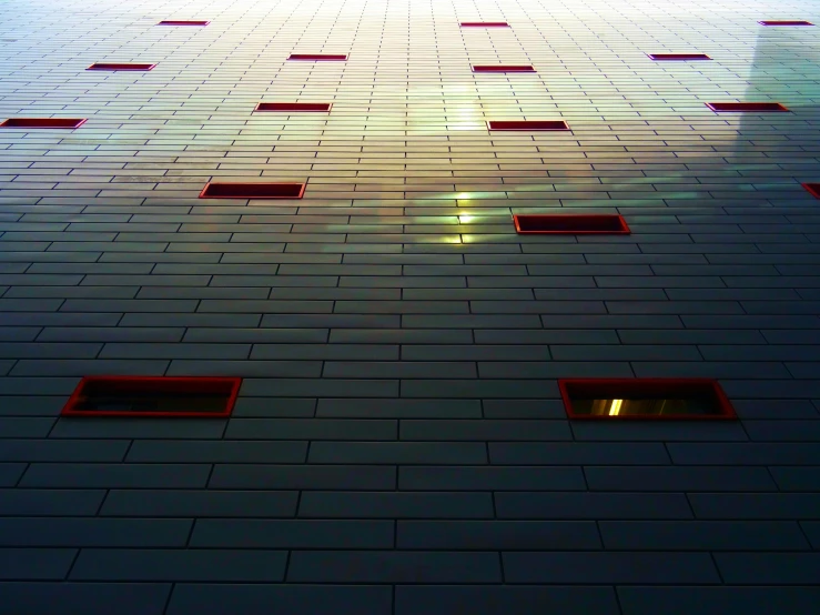 a very tall building with a lot of windows, a mosaic, inspired by Bauhaus, unsplash, light and space, red and blue back light, worm's eye view from the floor, instagram picture, metal panels