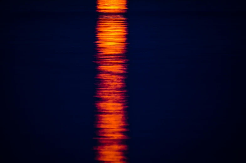 a full moon is reflected in the water, inspired by Jan Rustem, unsplash, minimalism, orange neon stripes, indigo and venetian red, intense sunlight, color ( sony a 7 r iv