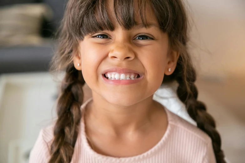 a little girl with a big smile on her face, slightly tanned, underbite, woman with braided brown hair, professionally post-processed