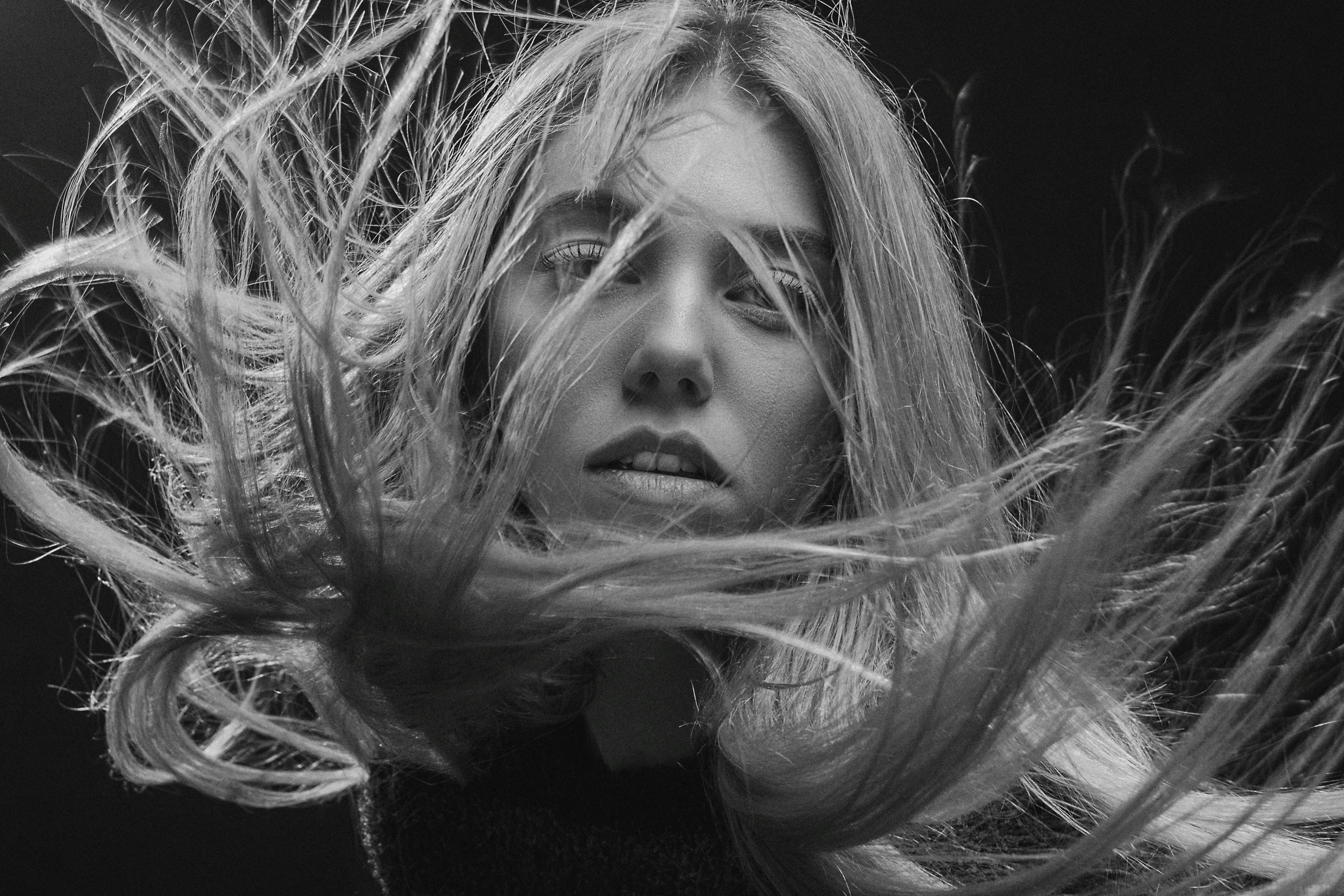 a woman with long hair blowing in the wind, a black and white photo, by irakli nadar, unsplash contest winner, natalia dyer, portrait of florence pugh, white hairs, maxim sukharev