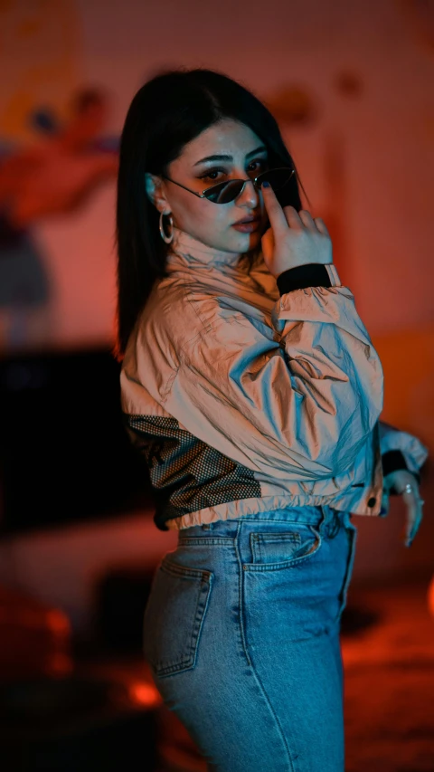 a woman in a white shirt and jeans talking on a cell phone, an album cover, inspired by Elsa Bleda, trending on pexels, holography, she wears a jacket, female dancer, night photo, indoor picture
