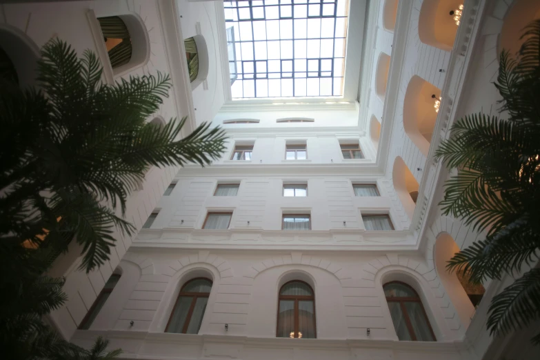 a very tall building with a skylight above it, unsplash, art nouveau, white marble interior photograph, hotel room, naples, square