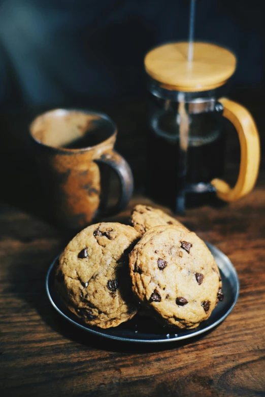 a plate of chocolate chip cookies next to a cup of coffee, a still life, unsplash, photorealism, highly detailed saturated, pot, high lights, rustic