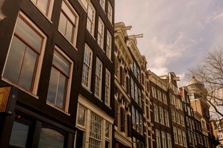 a clock that is on the side of a building, by Jan Tengnagel, pexels contest winner, neoclassicism, view of houses in amsterdam, profile image, extra high resolution, late afternoon light