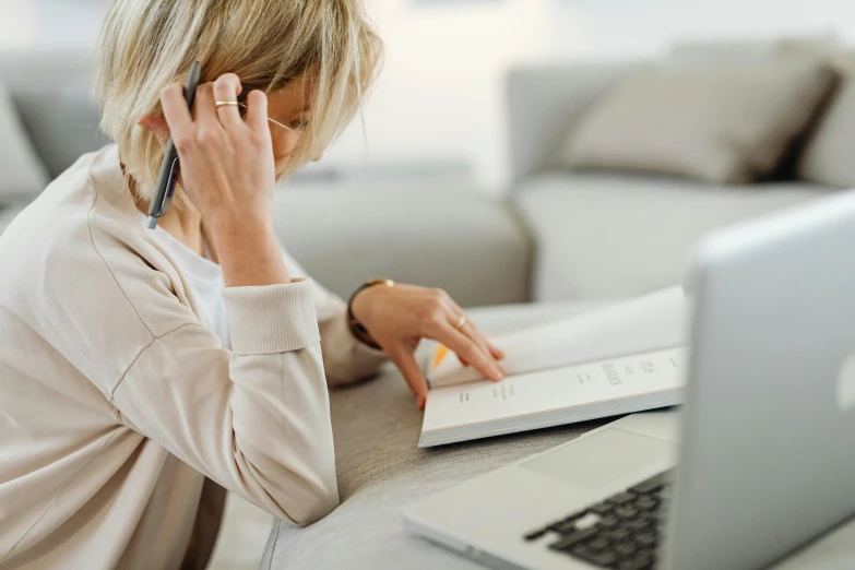 a woman sitting at a table with a laptop and a cell phone, worksafe. instagram photo, writing a letter, royal commission, 15081959 21121991 01012000 4k