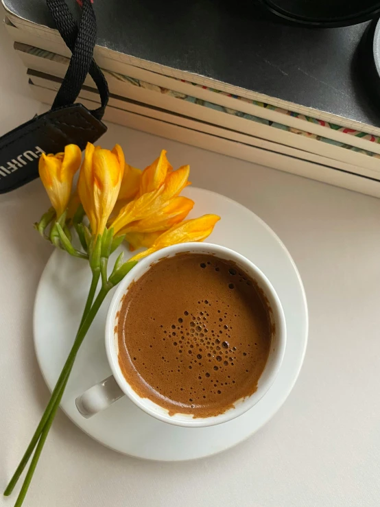 a cup of coffee and a flower on a table, by Lucia Peka, hurufiyya, dark-skinned, promo image, multiple stories, brown:-2