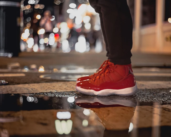 a person standing on top of a puddle of water, pexels contest winner, graffiti, rich red, basketball sneaker concept art, glossy reflections, holiday season
