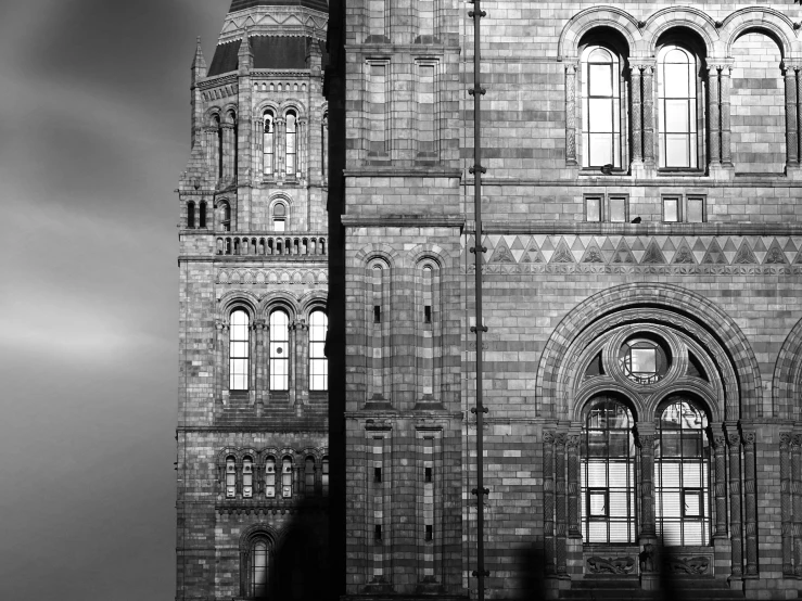 a black and white photo of a clock tower, a black and white photo, inspired by Thomas Struth, natural history, tall windows lit up, opalescent palace, two towers