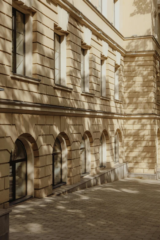 a man riding a skateboard down a street next to a tall building, danube school, classical architecture, gold dappled light, stone facade, archviz