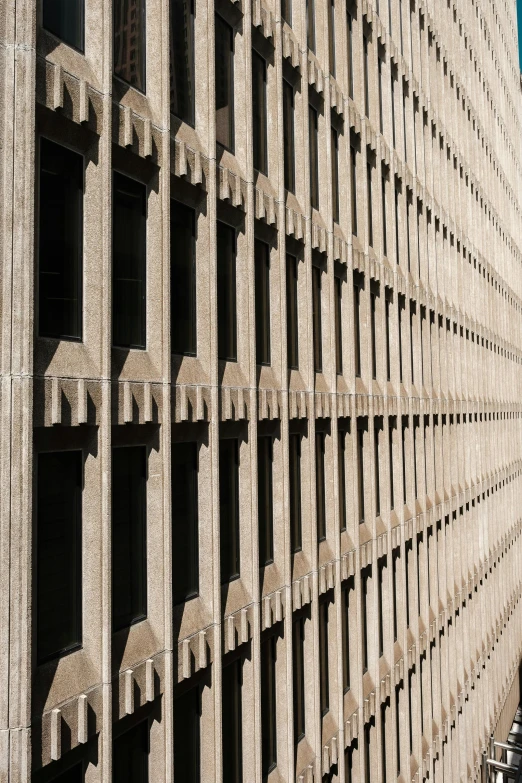 a very tall building with a lot of windows, inspired by David Chipperfield, unsplash, brutalism, brown, medium closeup, floor grills, buildings carved out of stone