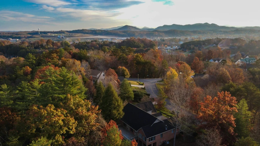 an aerial view of a small town surrounded by trees, by Neil Blevins, unsplash contest winner, visual art, sunset with falling leaves, “ aerial view of a mountain, tn, residential area