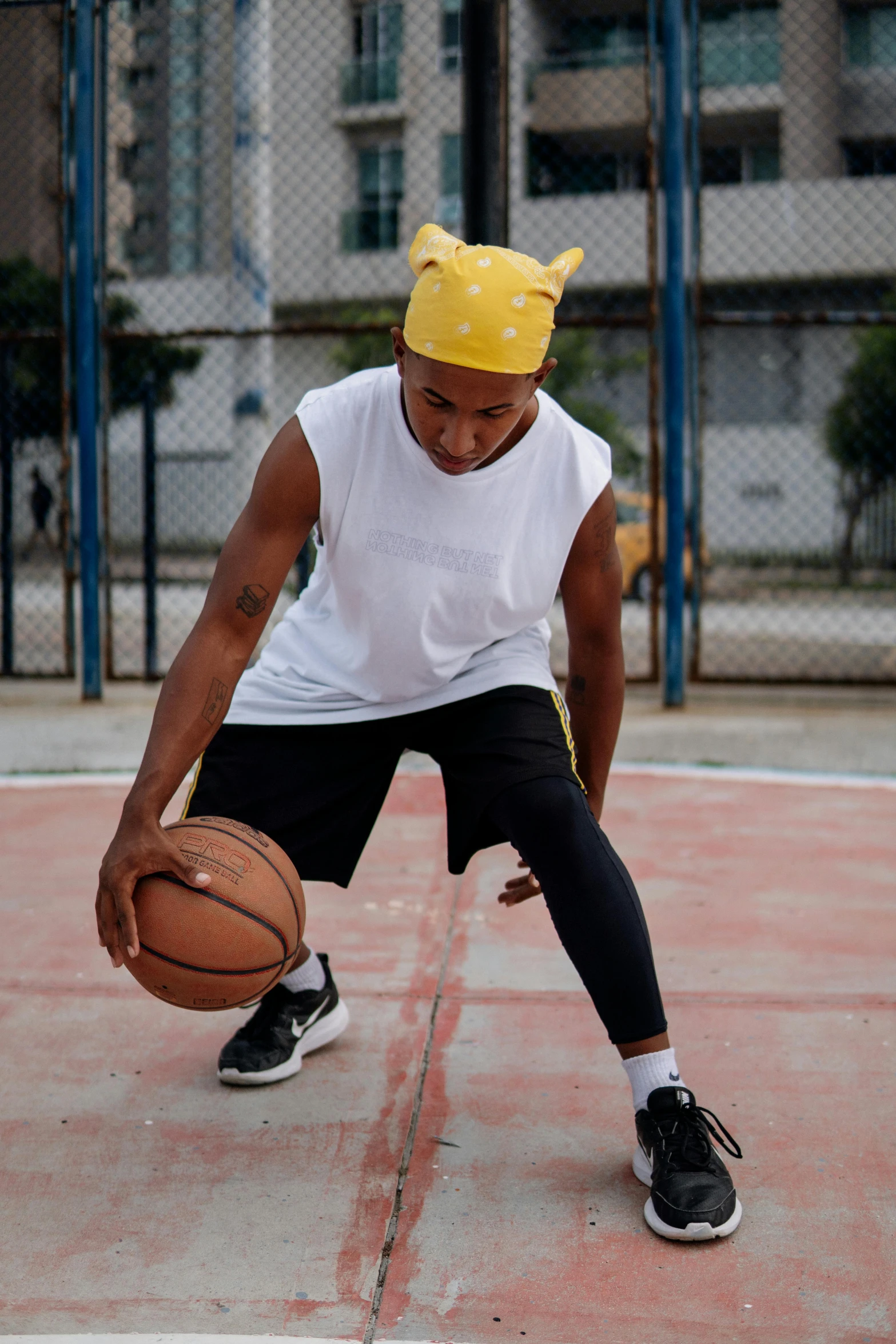 a man dribbling a basketball on a basketball court, by Paul Bird, trending on dribble, woman with cat ears, yellow cap, wearing : tanktop, streetwear