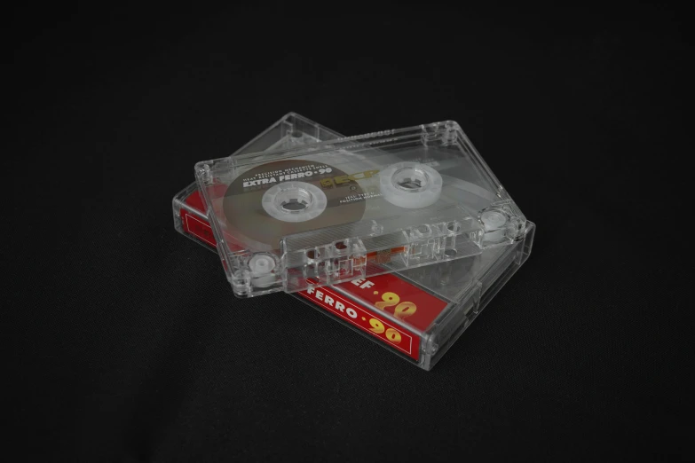 a couple of cassettes sitting on top of each other, by Jesús Mari Lazkano, plasticien, jewel case, clear, 8 k - h 7 0 4, very large