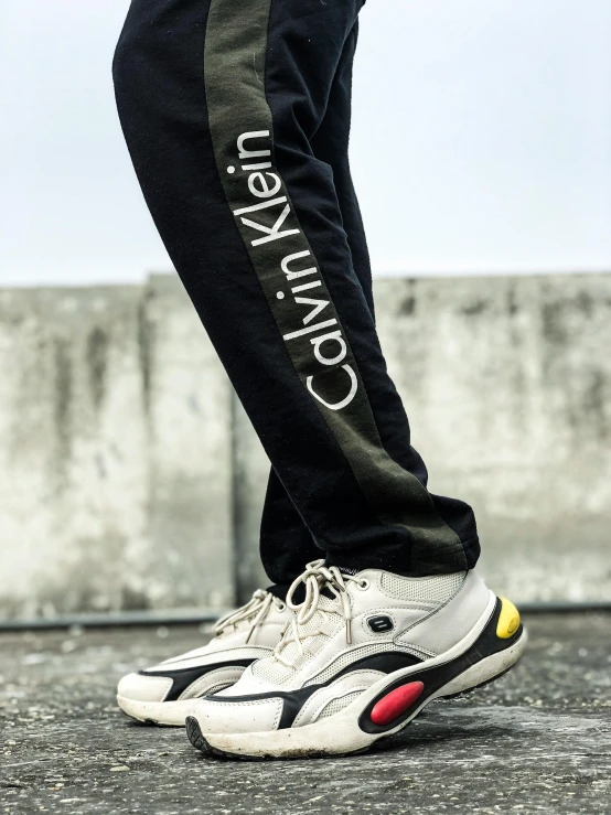 a close up of a person wearing a pair of sneakers, an album cover, inspired by Raphaël Collin, realism, calvin klein photography, military pants, 1997 ), trending on r/streetwear