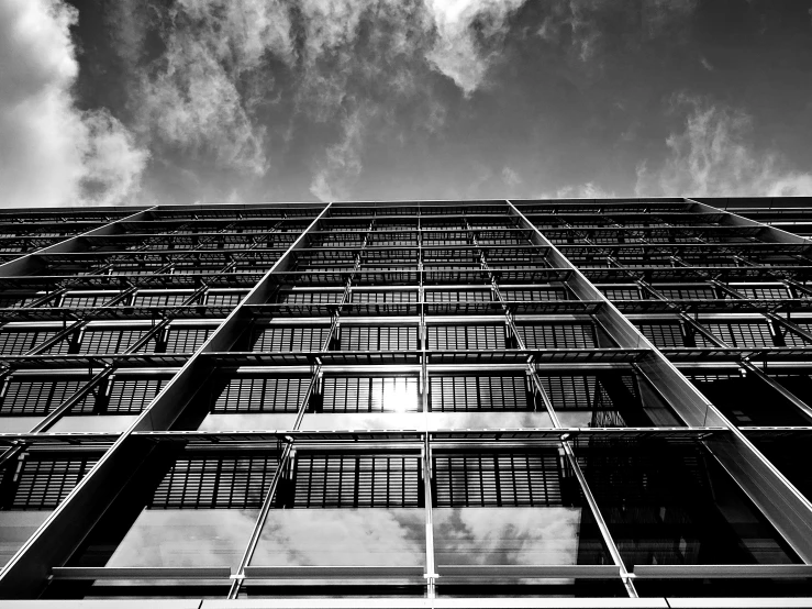 a black and white photo of a tall building, a black and white photo, pexels, brutalism, glass ceilings, hot summer sun, front view dramatic, high quality upload