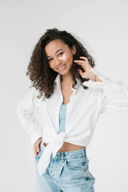 a woman with curly hair wearing a white shirt and jeans, trending on unsplash, portrait sophie mudd, on white, sza, promotional image