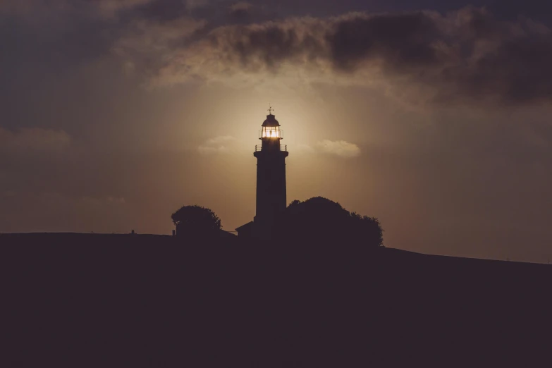 a lighthouse sitting on top of a hill under a cloudy sky, a picture, unsplash contest winner, romanticism, nightlight, brown, bright rim light, instagram post